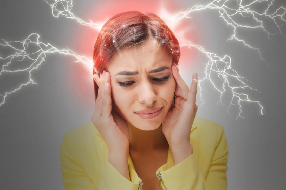 Woman in pain with hands against her head