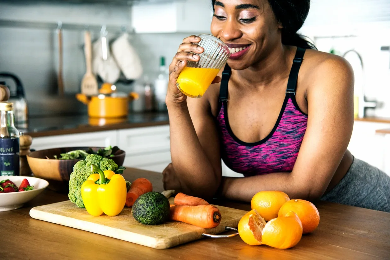 Smiling woman drinking juice. Toxins, toxicity, detoxification and hyperbaric therapy (HBOT).